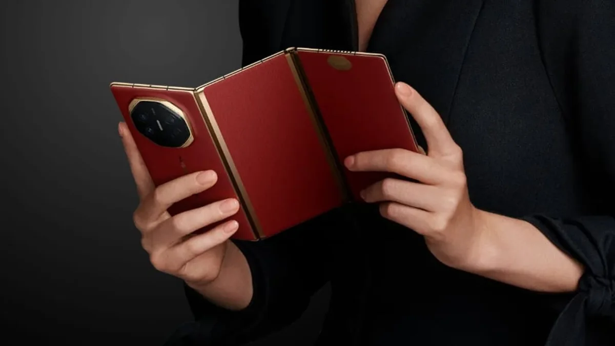 Hands holding an open red tri-fold phone against a dark background