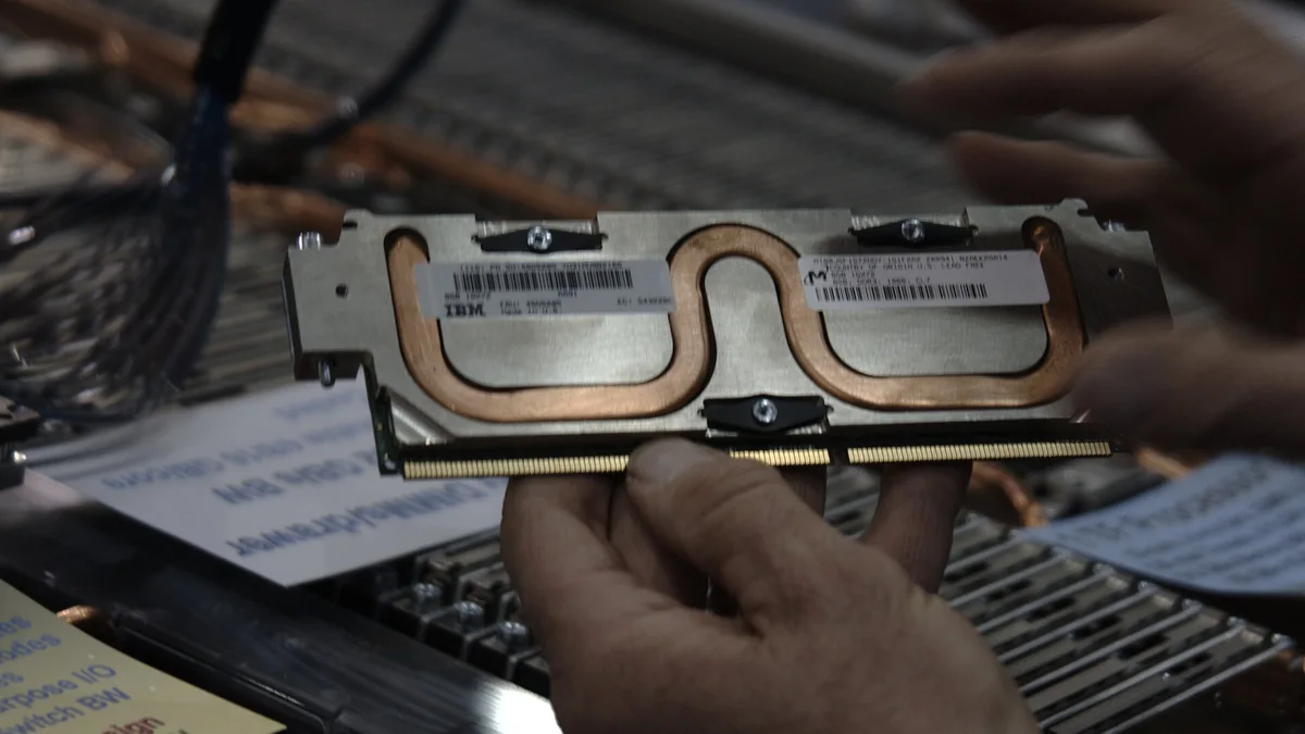 Hands installing a memory module into a server board