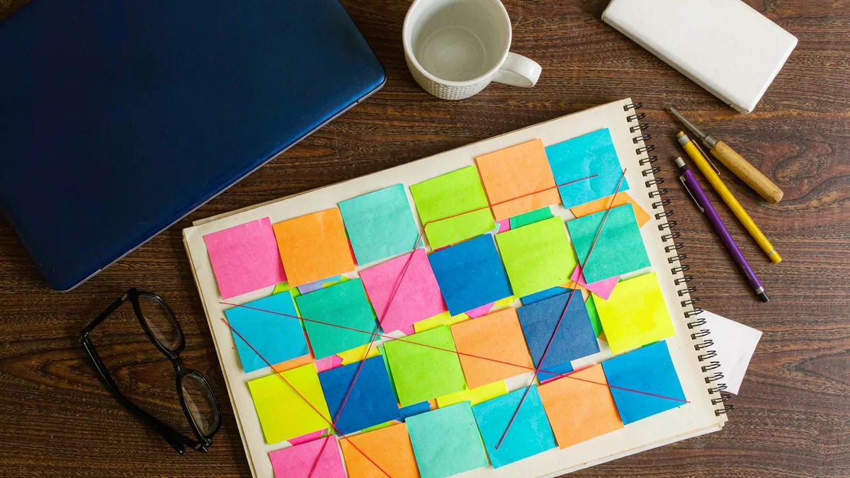 A desk with a laptop and sticky notes, top-down view