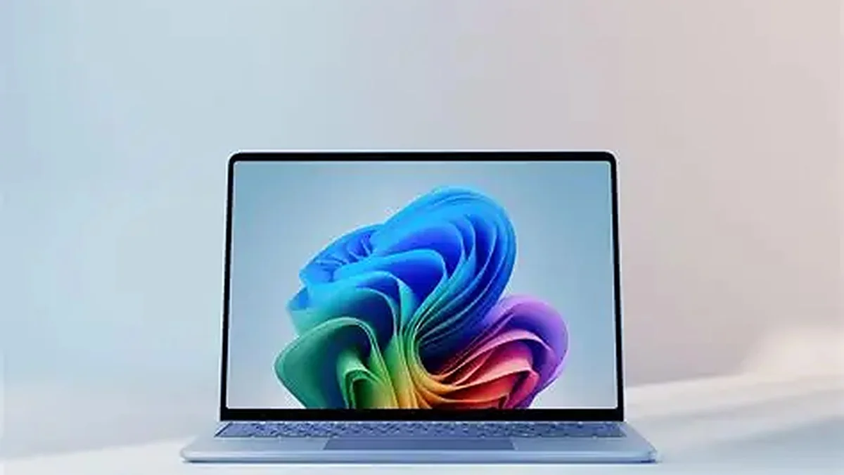 A light blue Surface laptop with a colorful swirl wallpaper