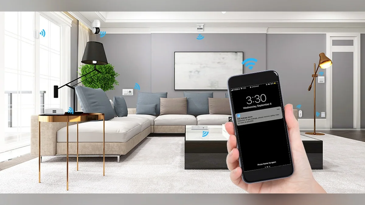 Hand holding a phone showing a smoke alarm alert in a smart living room